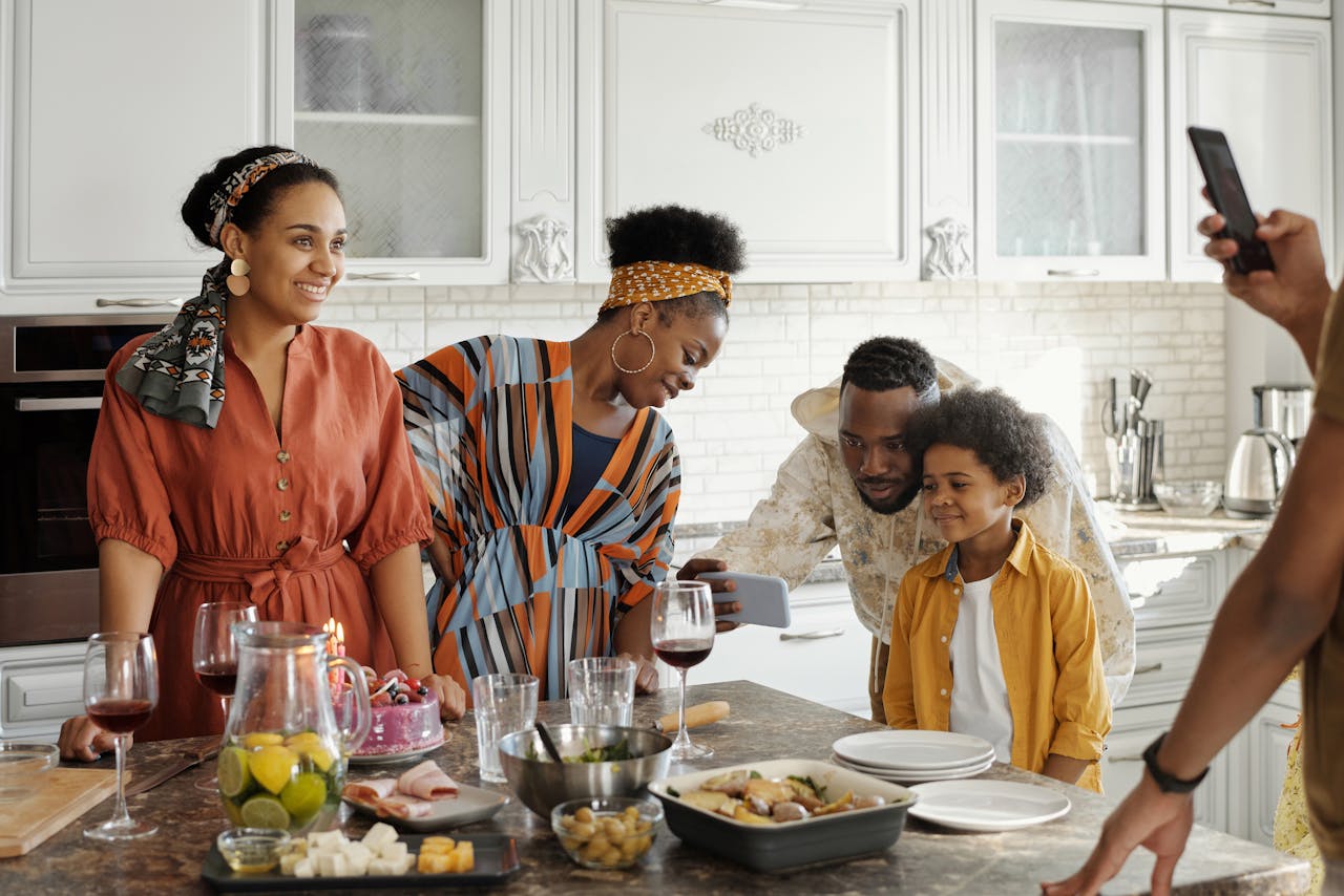 Family enjoying a cheerful gathering in a bright modern kitchen, capturing memories together.